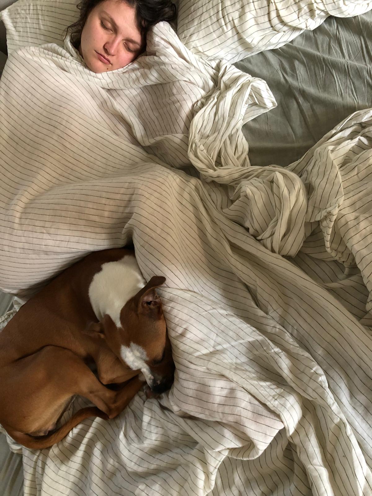 Jo asleep under a linen sheet, with Marmalade curled up in the crook of his knees