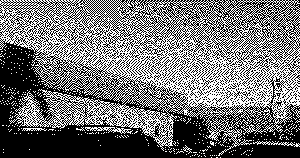Exterior of a bowling alley. The bowling pin sign says MEOW WOLF.
