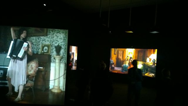 [view of three of the screens in The Visitors]