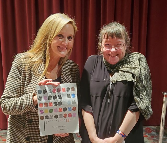 Samantha Bee and Kristin Henry. Bee is holding a Data Art print showing the colors of blazers she wore on her show Full Frontal.
