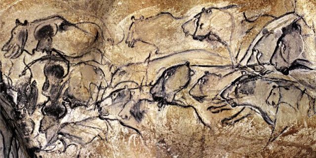 black line drawings of lioness heads stacked in two rows on a cave wall