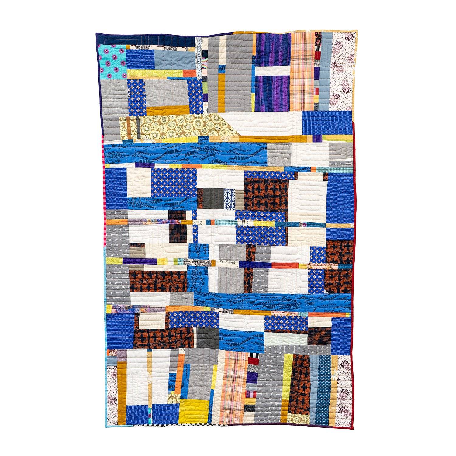 Patchwork quilt including fabrics in blue, white, grey, gold, and purple.