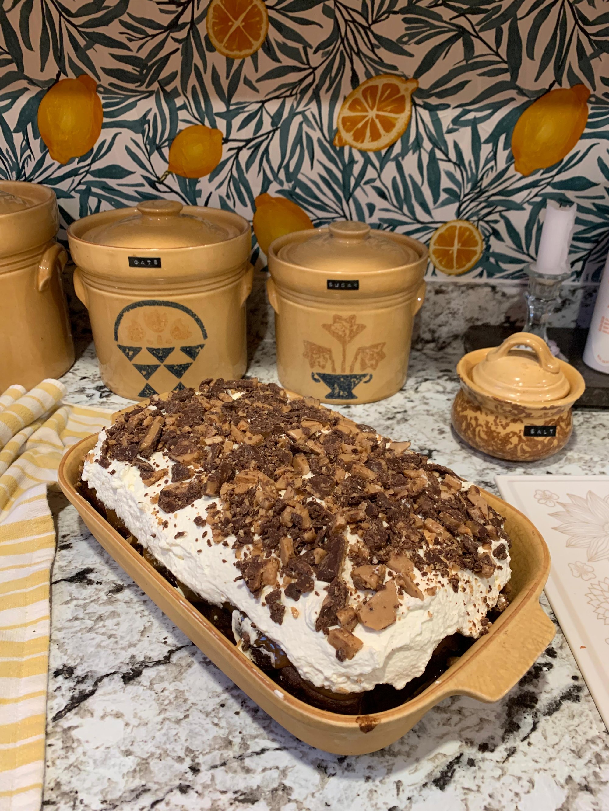 Emory’s chocolate caramel toffee cake on the counter in front of the quilt pattern-painted storage jars and the new lemon backsplash.