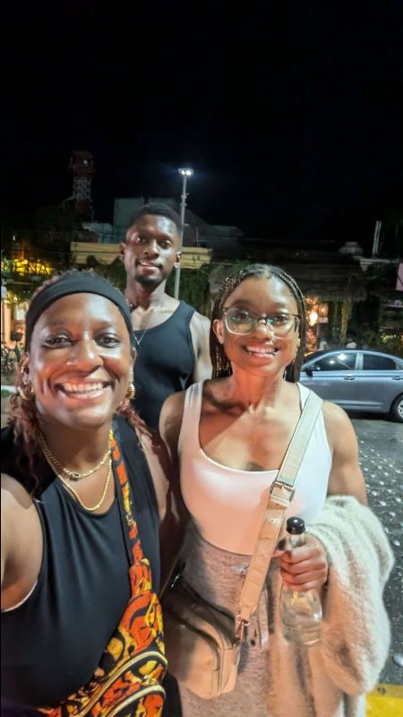 Photo of me and my brother and sister outside at night on a street in Tulum.