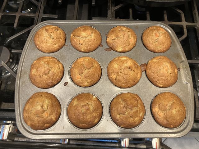 golden brown muffins still in the tin, hot out of the oven