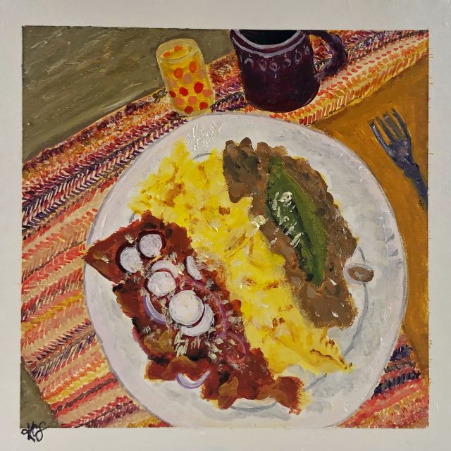 a plate with chilaquiles, eggs, and beans on a colorful placemat 