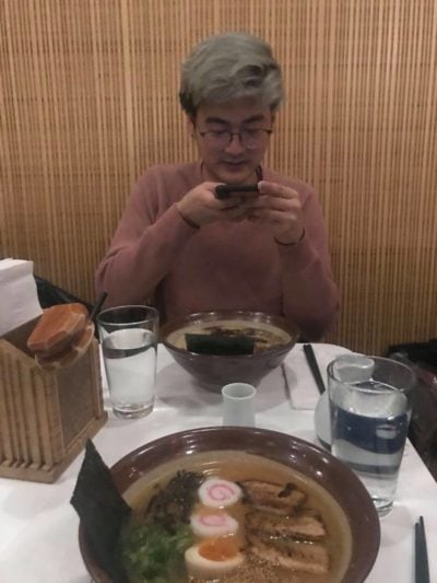 a picture of joon taking a picture of ramen