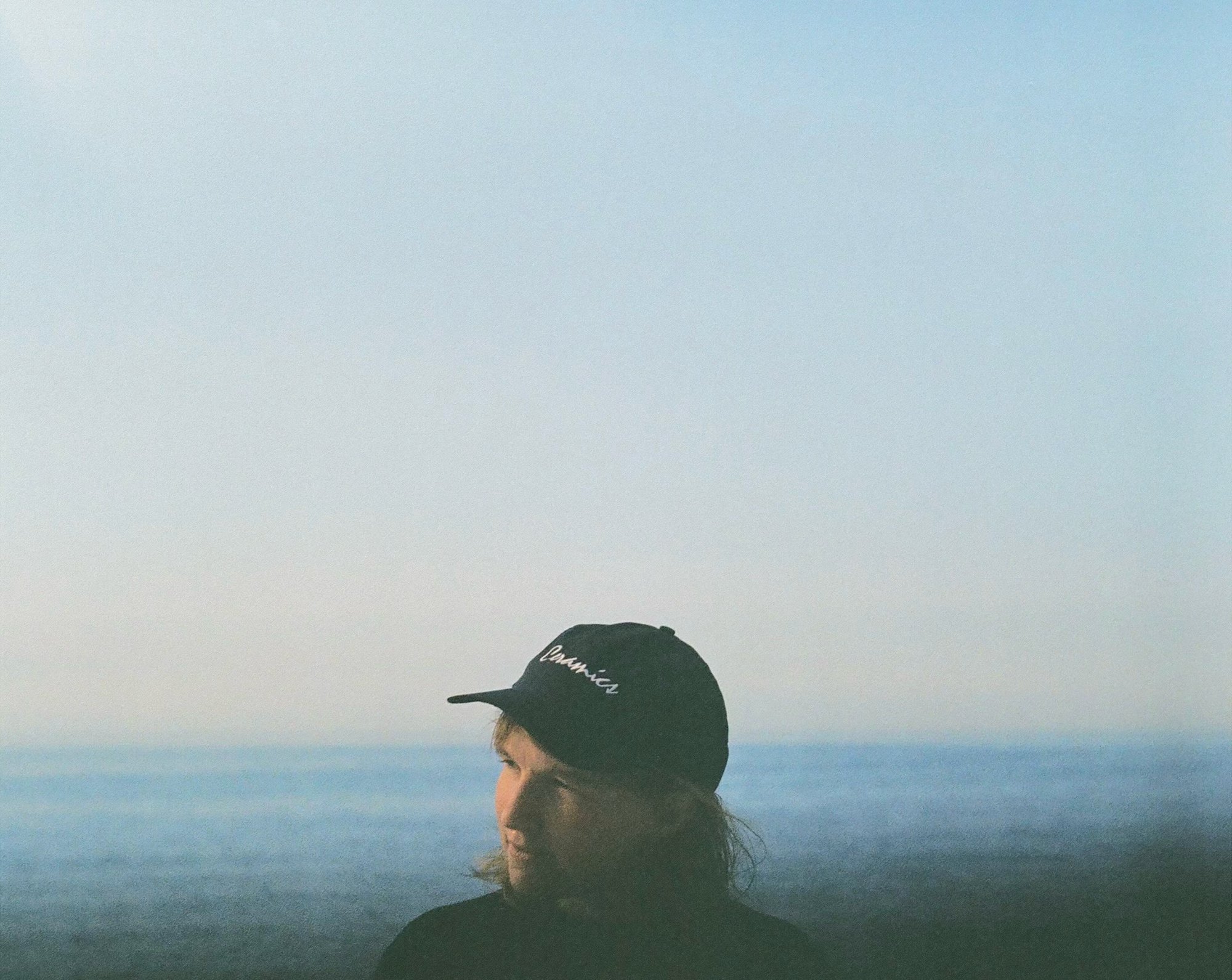 Photo by Ellen Rutt, me standing in front of Lake Michigan at Christmas Cove wearing a hat that says
