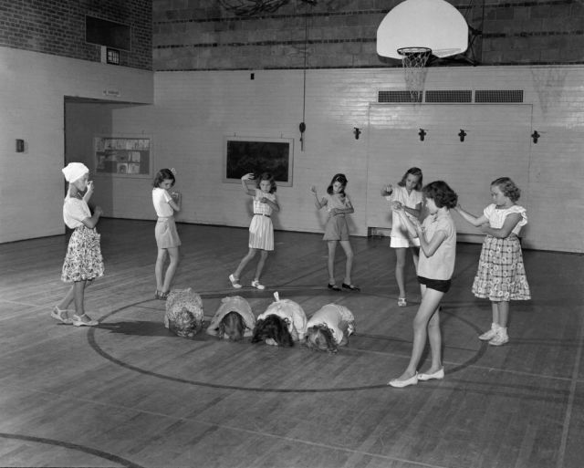 girls playing unknown game in gym, 1950s