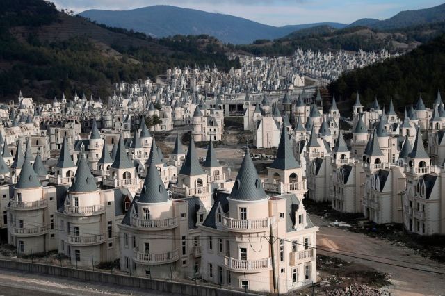 Photograph of a valley in Turkey with dozens of distasteful small mansions looking like castles, all looking exactly the same and placed next to each other