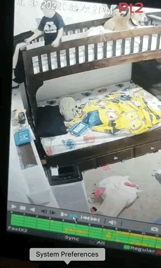 A dog yawns and lays down while one kid tries to pull another kid out of being stuck behind a bunkbed.