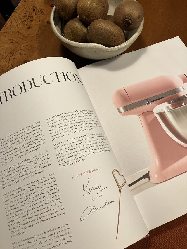 a photo of the introduction page of CHERRY BOMBE next to a bowl of kiwis
