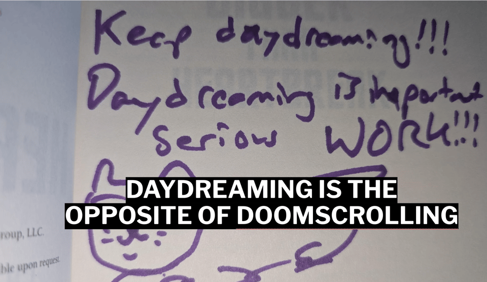 A copy of one of my books. I scribbled "Keep daydreaming. Daydreaming is important, serious WORK!!!" And I drew a silly cat picture. Over that is written DAYDREAMING IS THE OPPOSITE OF DOOMSCROLLING