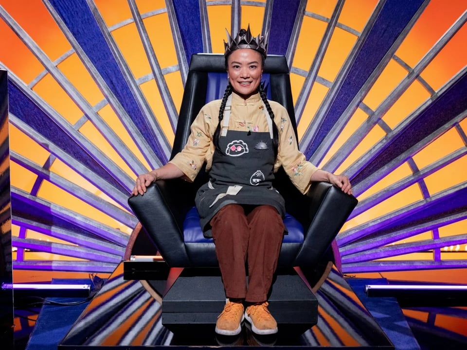 a woman sitting in a chair with beams of purple and yellow behind it