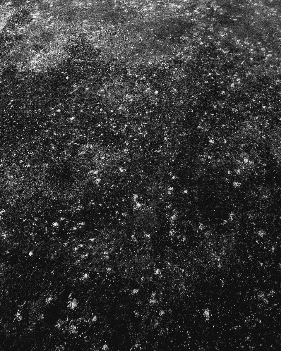 salt stains on black asphalt create the illusion of a field of stars