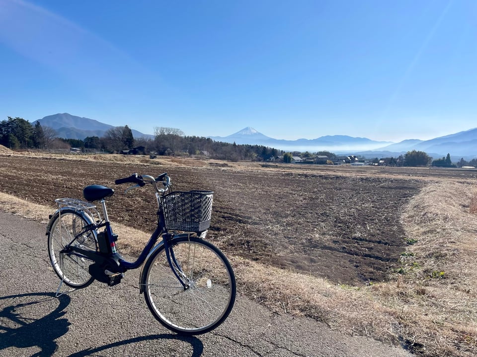 E-bike in front of a field, with Mt Fuji in the distance