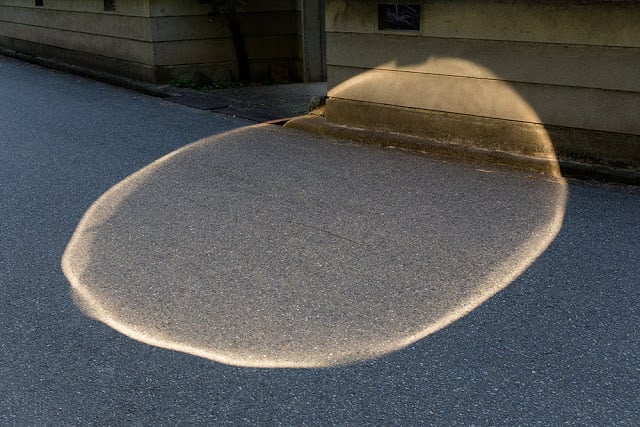 a photo of a pool of light on the asphalt