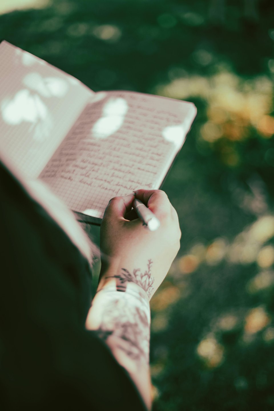 Photo by Kitty S: https://www.pexels.com/photo/tattooed-arm-writing-in-journal-outdoors-32831635/