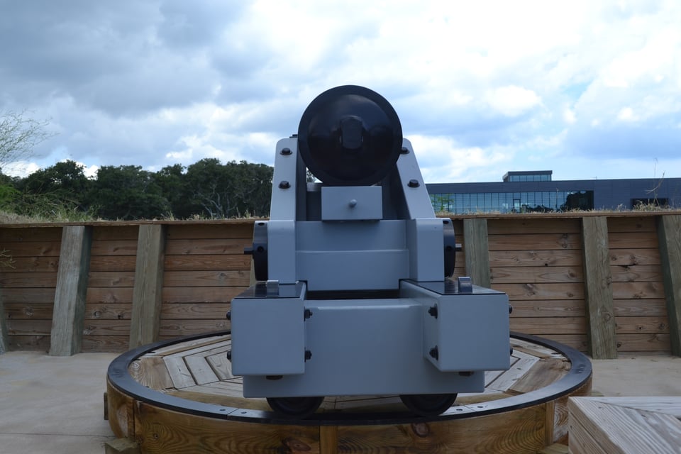 A gun emplacement, seen from the rear, with the butt of a cannon visible on its turret.