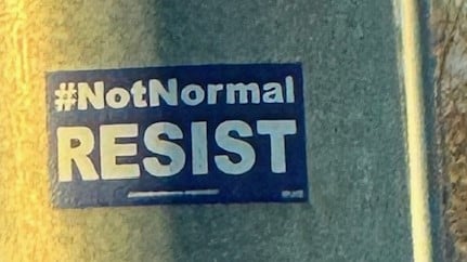 a sign that says "Not normal. Resist."