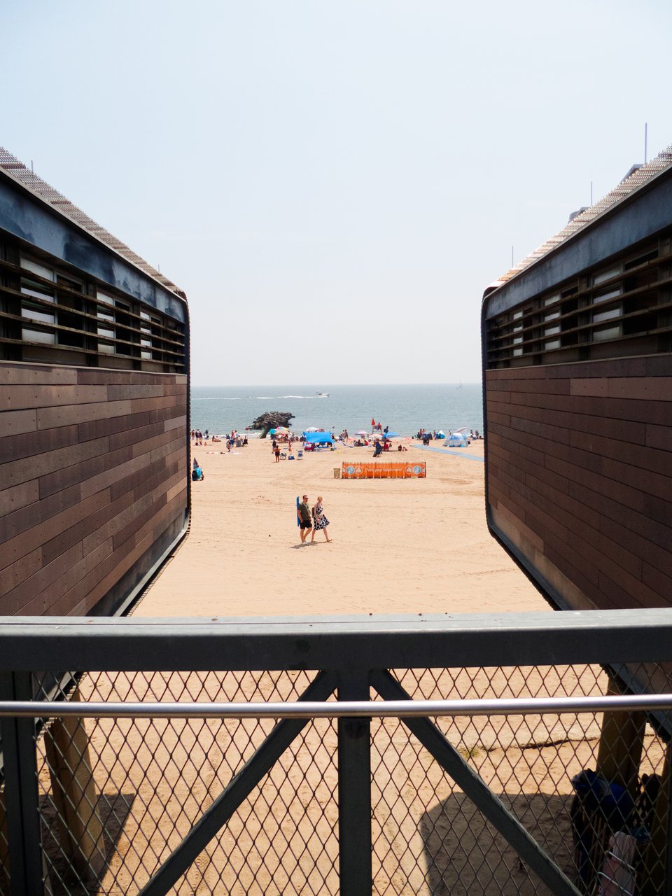a view of the beach between the lofted bathrooms.