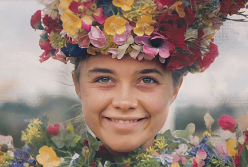a picture of Florence Pugh as her character in Ari Aster's Midsommar, smiling as she witnesses unspeakable horror and wears a crown and cape of lovely flowers