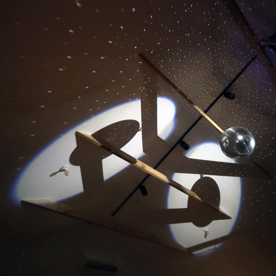 a disco ball at a strange angle throws a shadow in the shape of mean cartoon eyes