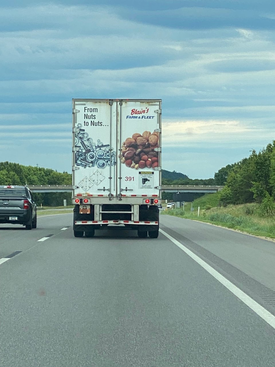 The back of a semi truck that says "From Nuts to Nuts..."