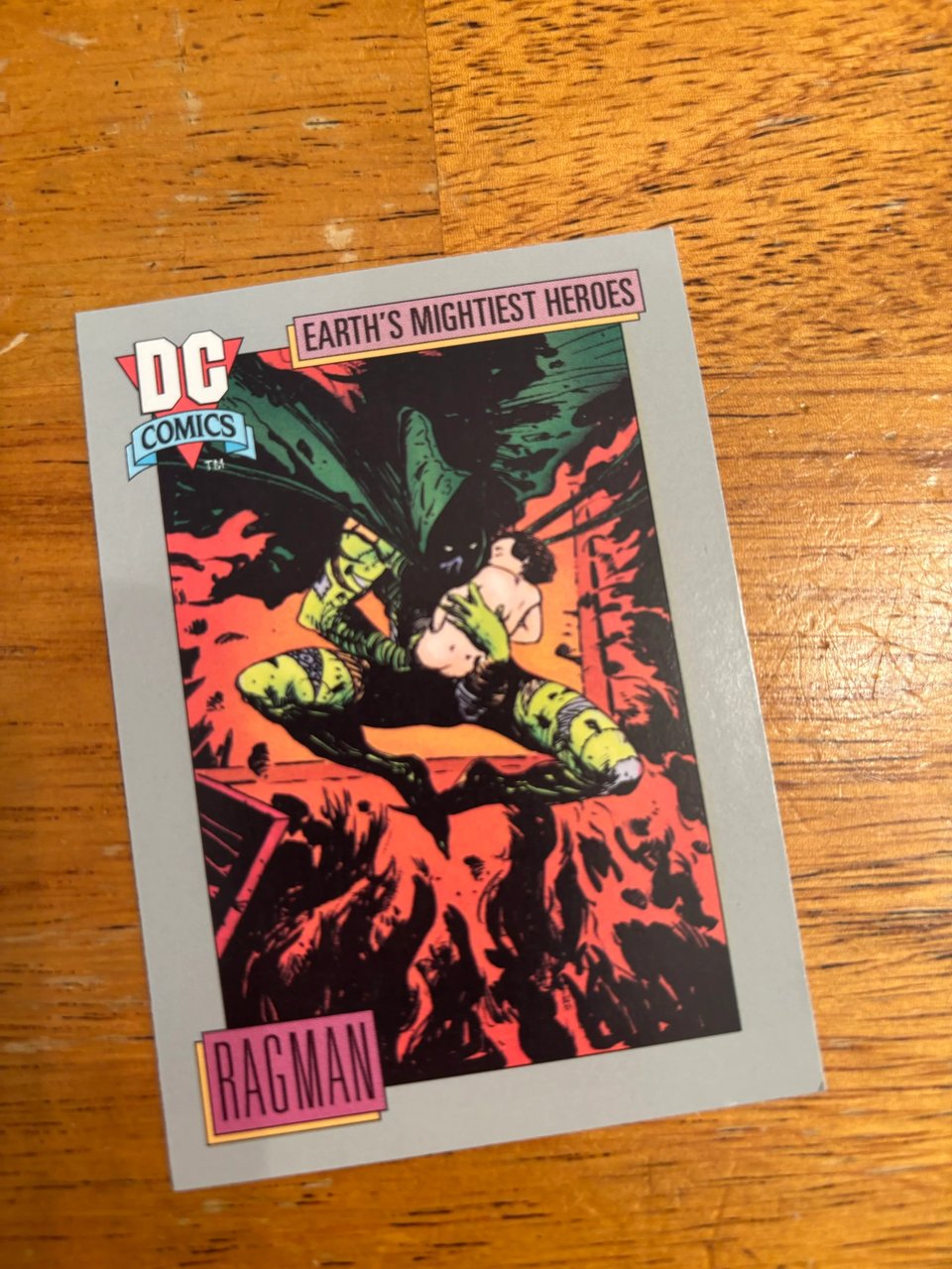1991 DC comics Ragman card against a wood grain table, drawn by George Pratt