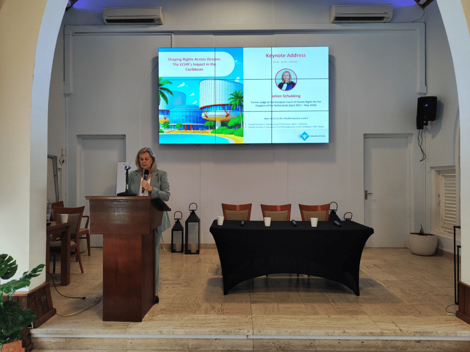 The opening keynote, Jolien Schukking, standing in front of the Aula at the University of Aruba.