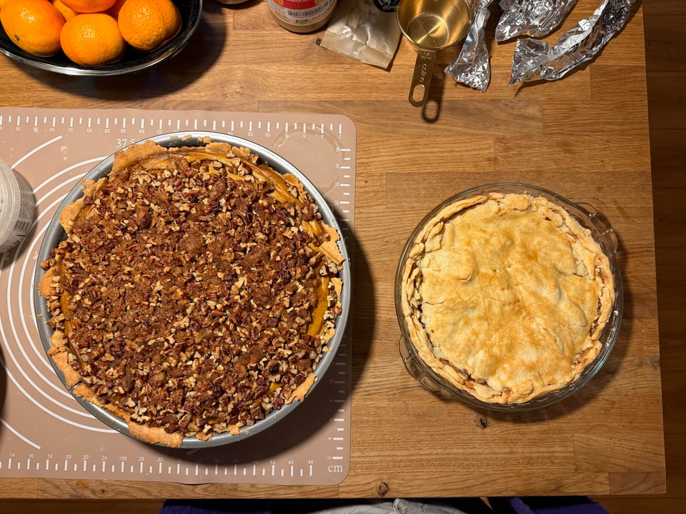 Two pies side by side. A large Pecan Praline Pumpkin Pie and a smaller Apple Pie.