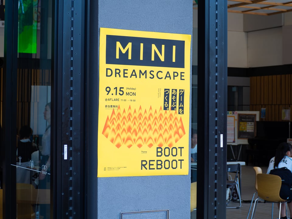 A yellow sign for DREAMSCAPE_MINI on a pole.