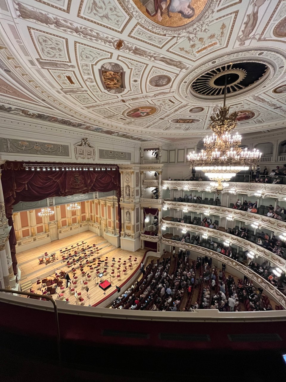 Opera house with 5 tiers, a huge chandelier, and a pastel frescoed ceiling