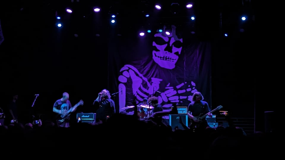 Orchid, a band, performing live in front of a skeleton banner