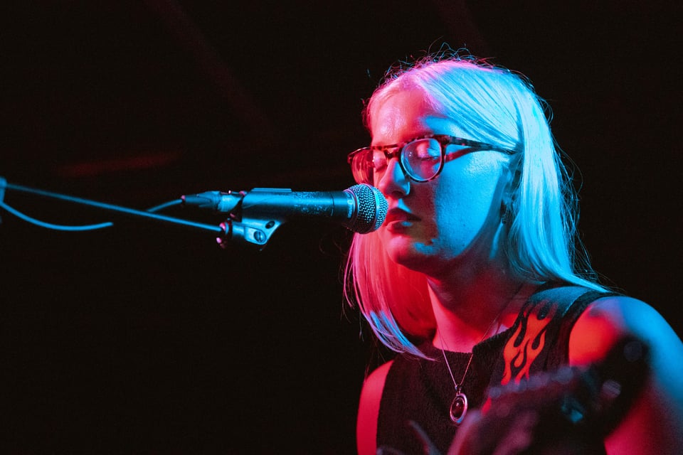 Em of God Grief looking radiant illuminated in Cassette's signature blue/red lighting