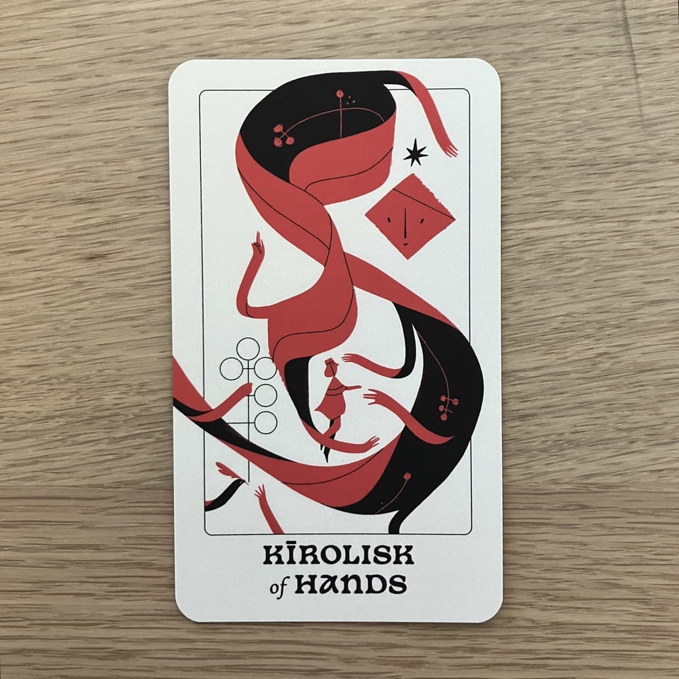 A card showing the Kīrolisk of Hands. A ribbon-like entity wraps around a seeker.