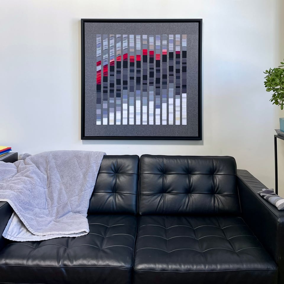 textile art on wall above sofa