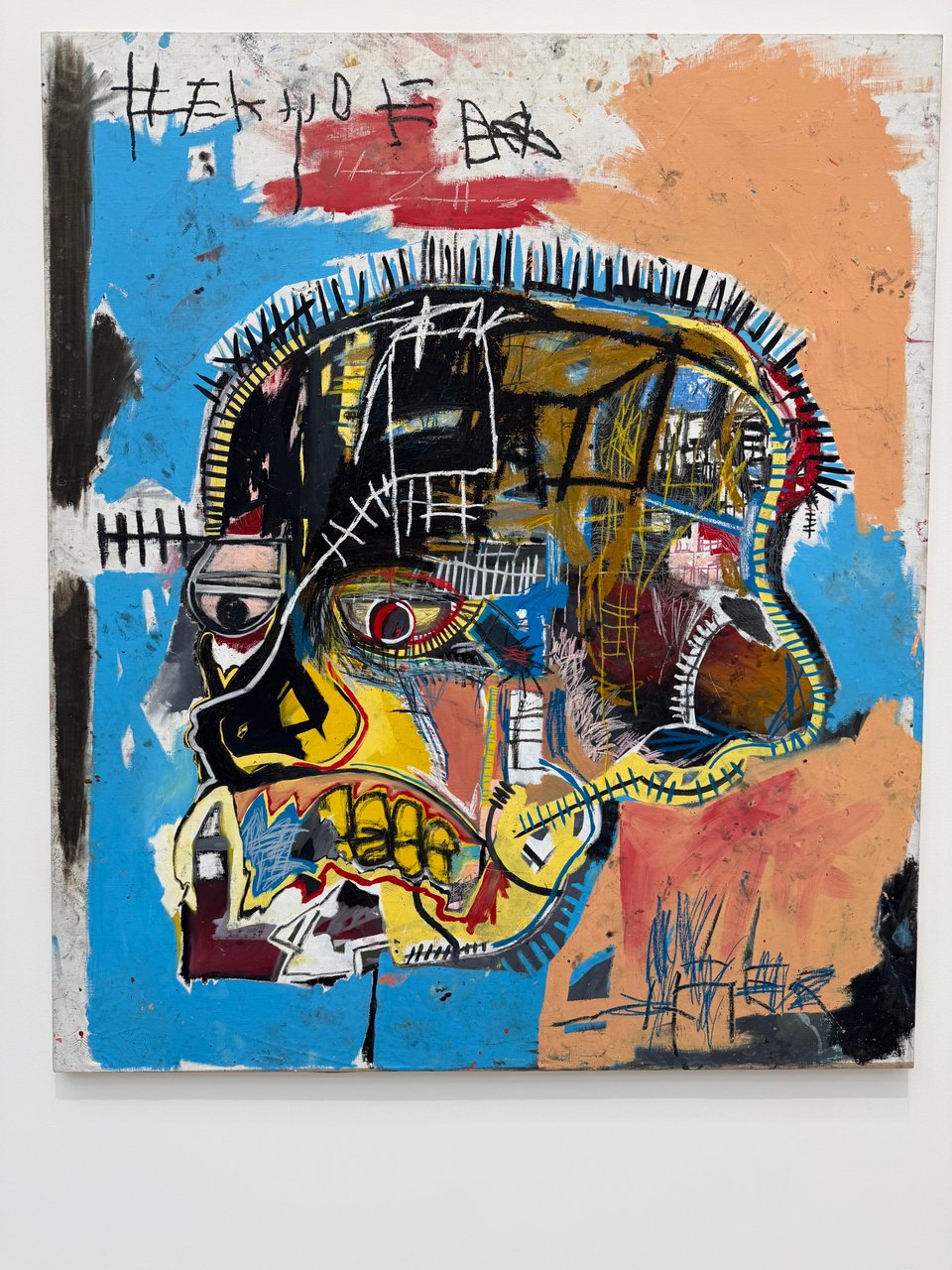 photo of an untitled and indescribable piece by Basquiat, of a skull but a lot of other stuff.