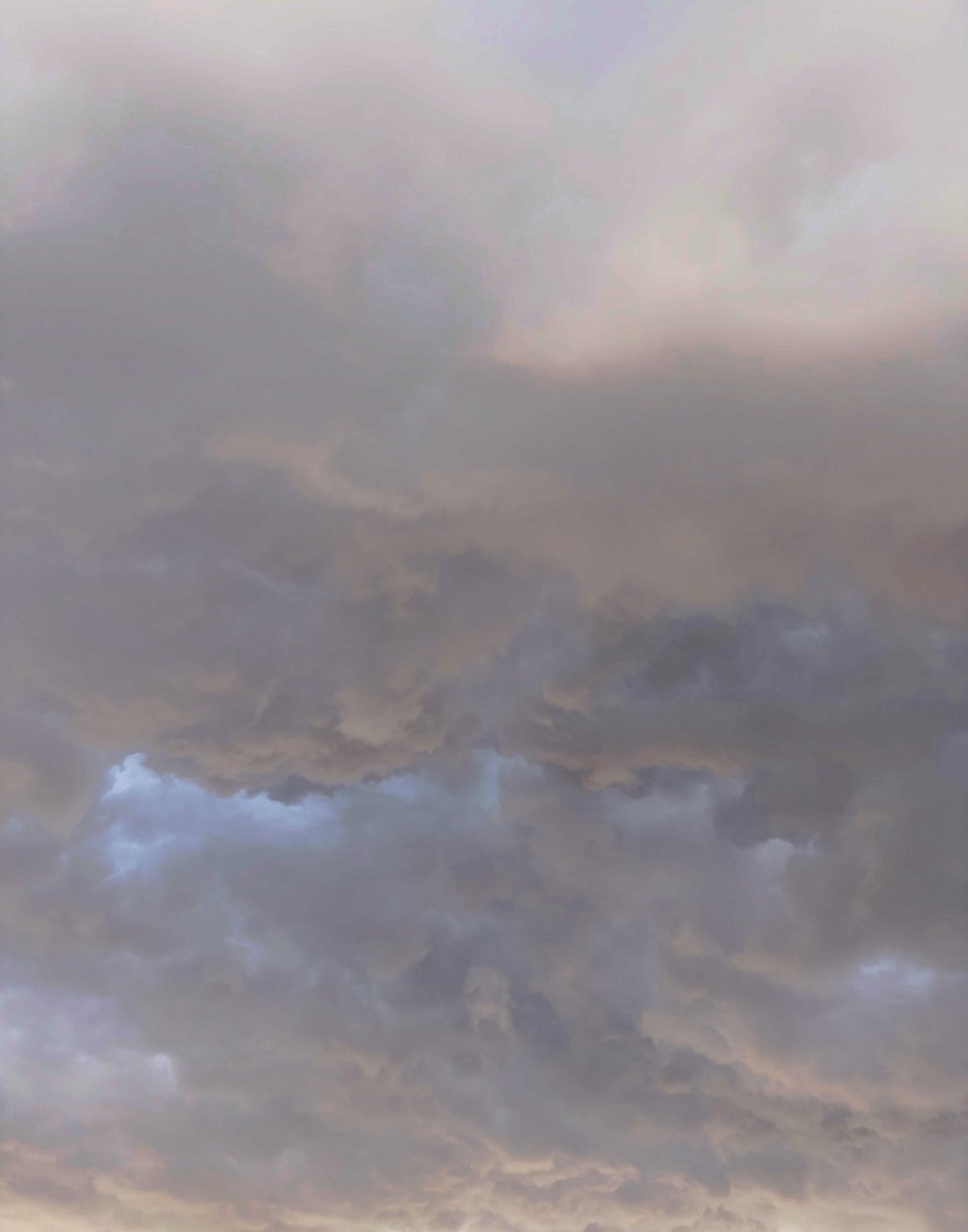 A soft photo of low clouds filling the frame, in colors ranging from rosy pink to deep purple-blue
