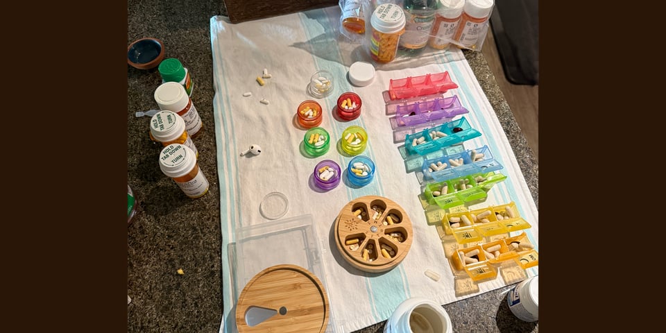 a top view of dozens of pill bottles and pill containers being filled