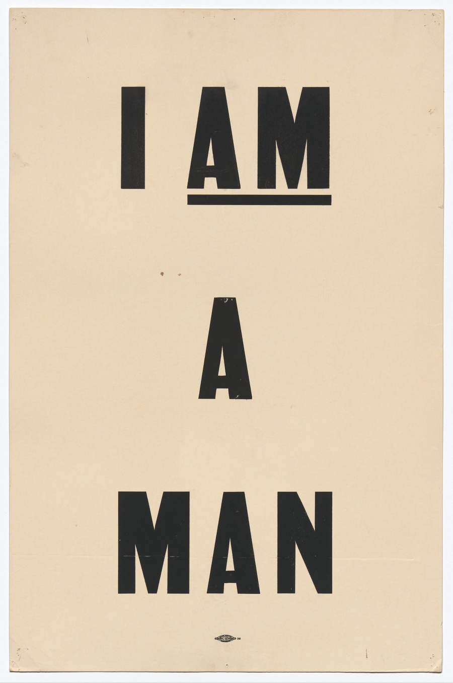Beige placard reading I am a man in black capital letters.