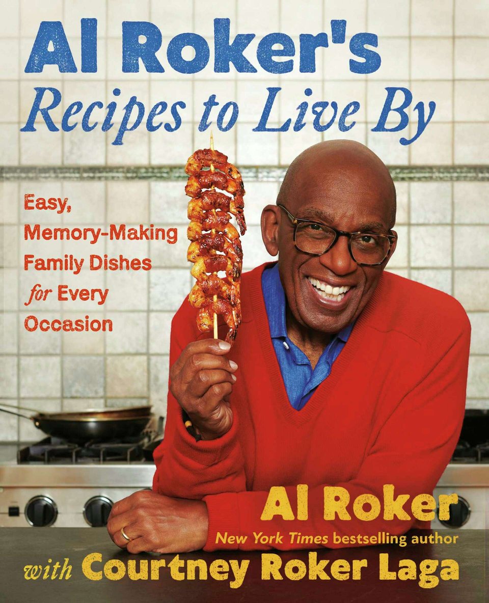 Phot oof the cover for Al Rocker’s Recipes To Live By, showing Al Roker in a red sweater leaning on a kitchen counter, holding a skewer with a bunch of bacon-wrapped shrimp on it