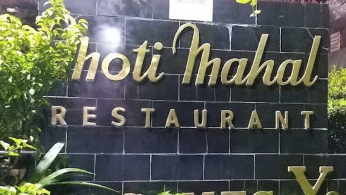 Sign for Moti Mahal restaurant in Delhi, gold letters on a black tiled wall