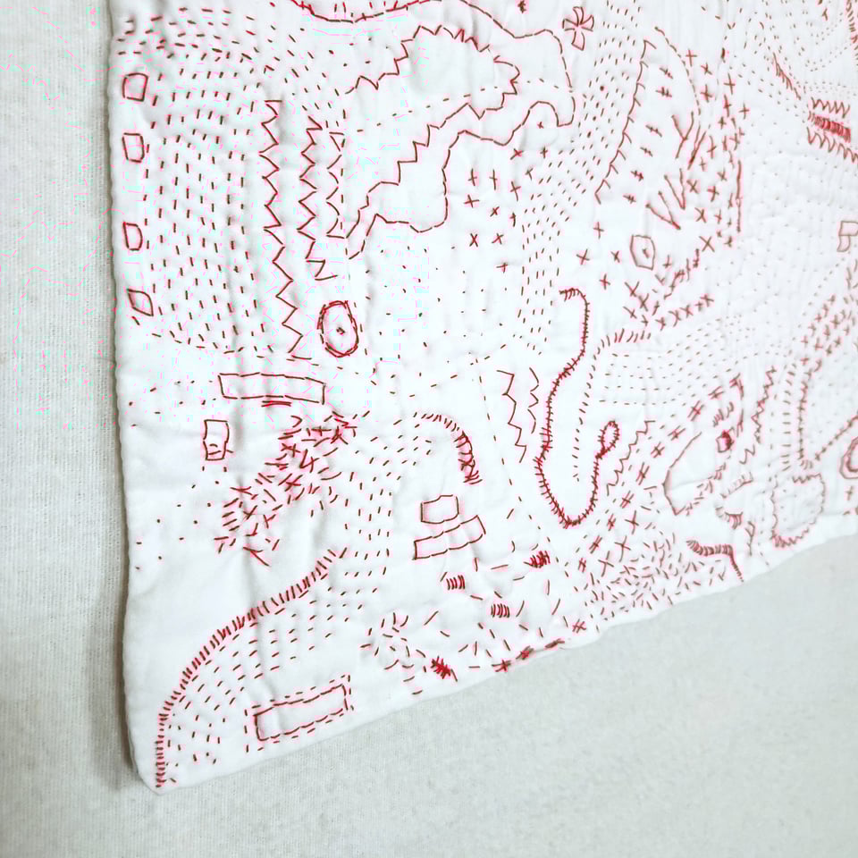 Detail of Red Map, a hand stitched quilt by Sarah Atlee. Red thread on white pillowcase, 2025.