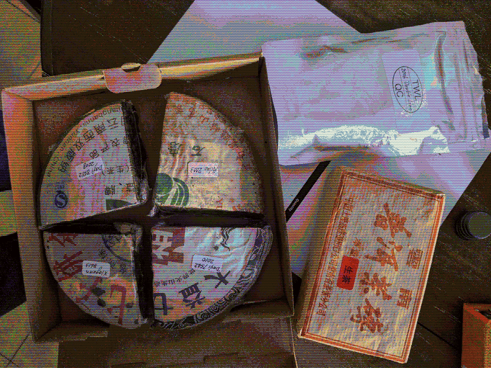 Four quarters of tea cakes, a tea brick, and a bag of tea.