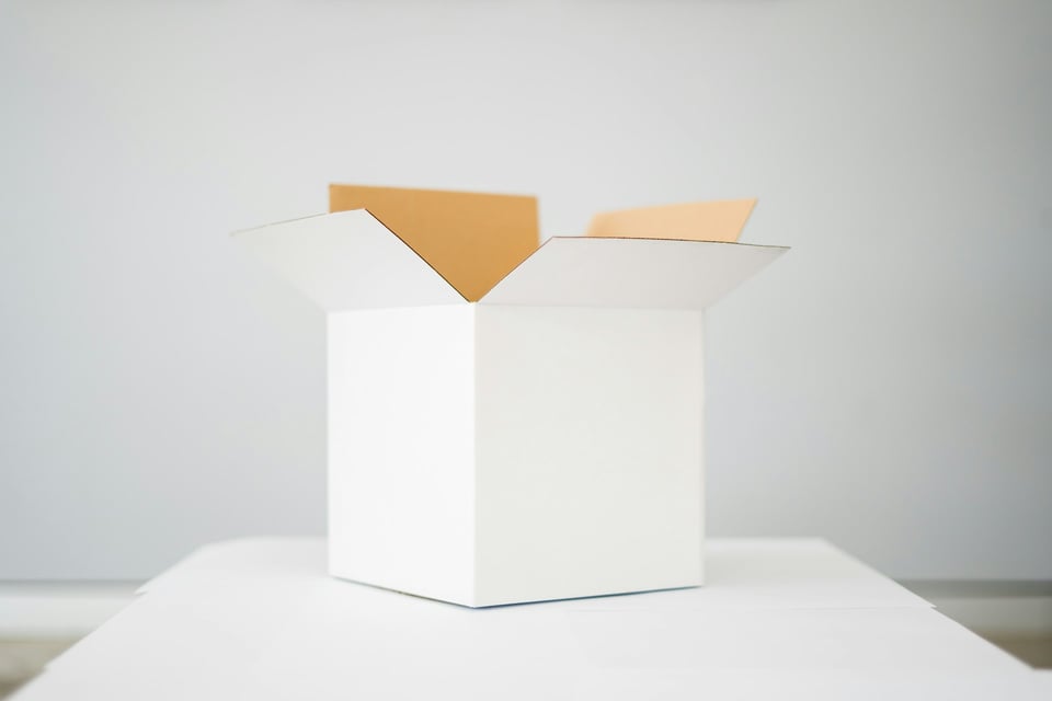 A white cardboard box, open, on a table. Photo by Kelli McClintock on Unsplash