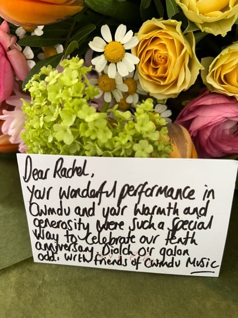 A bouquet of flowers with a note: Dear Rachel, your wonderful performance in Cwmdu and your warmth and generosity were such a special way to celebrate our tenth anniversary.