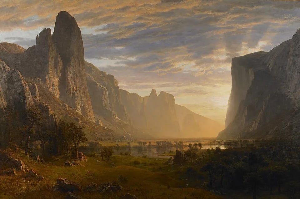 A luminous landscape painting depicts a vast mountain valley bathed in golden light. Towering cliffs rise steeply on either side, framing a tranquil river and meadow stretching into the distance. The warm glow of the setting or rising sun filters through a partly clouded sky, creating a dramatic contrast between shadowed rock faces and the radiant horizon