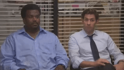 Two characters from "The Office" television program share a fist bump