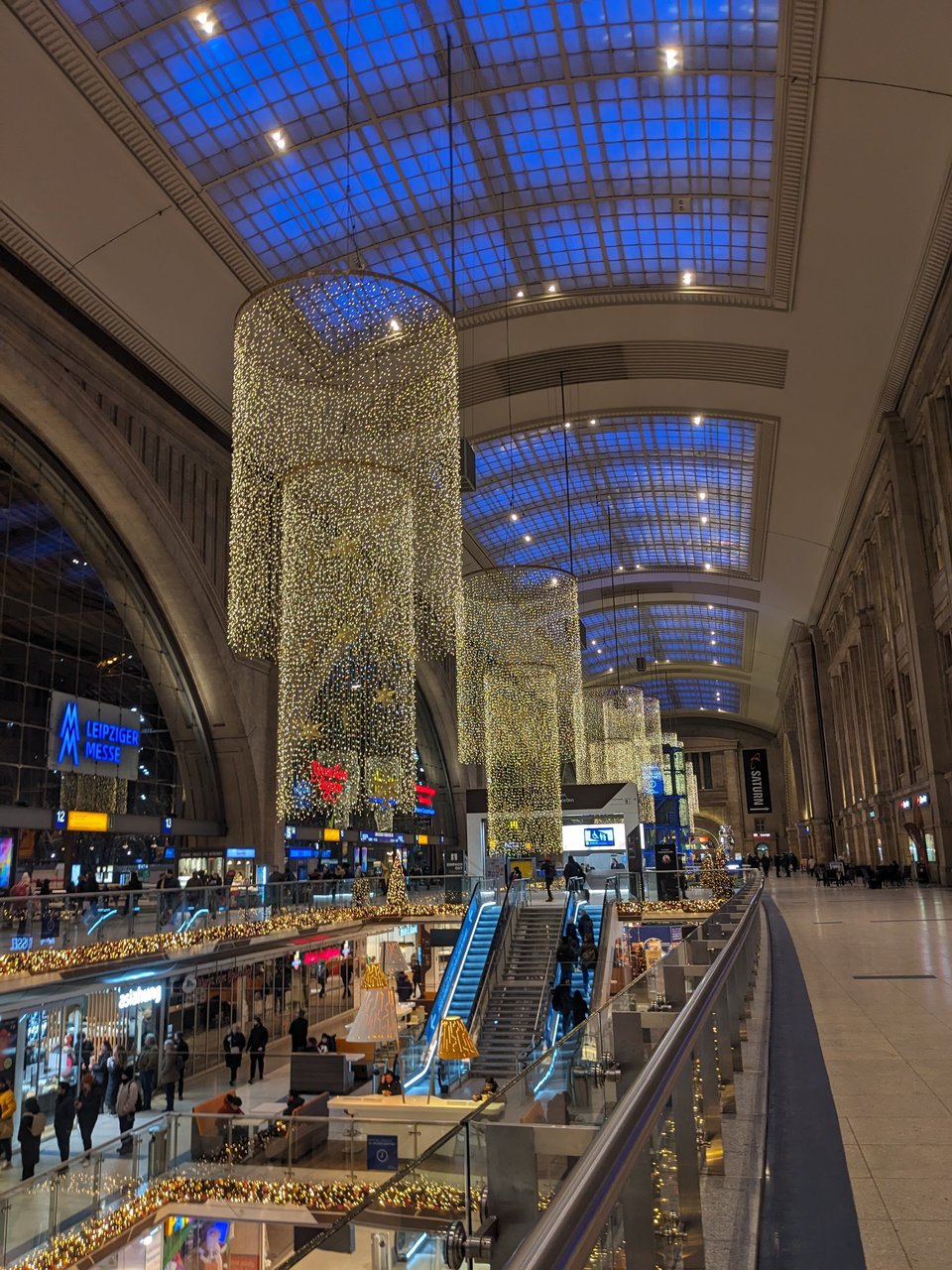 Chandeliers of nets of white Christmas lights are suspended from the ceiling of the large entryway of the Leipzig train station.